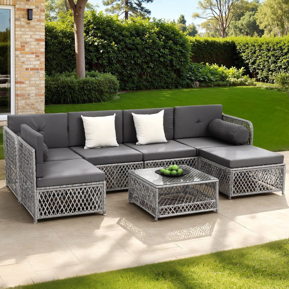 Outdoor patio furniture set with gray cushions on a patio area.