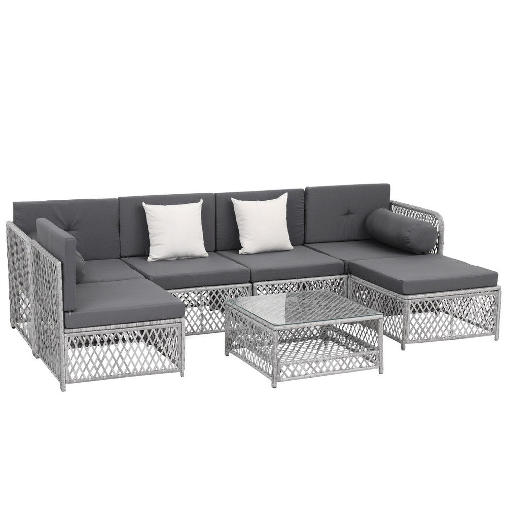 Outdoor furniture set with gray cushions and a glass table on a white background