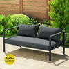 A Gardeon 2-seater Outdoor Aluminium Sofa in charcoal black colour, showing its weight capacity of 150kg and in a garden setting.