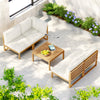 Outdoor patio furniture set with white cushions and a small table with fruit on a patio.