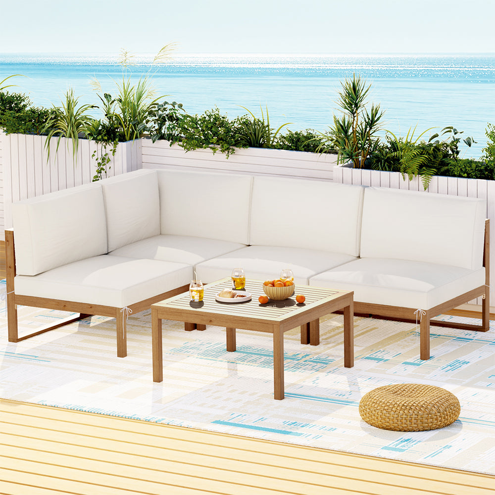 Outdoor patio set with white cushions and a small table on a deck.