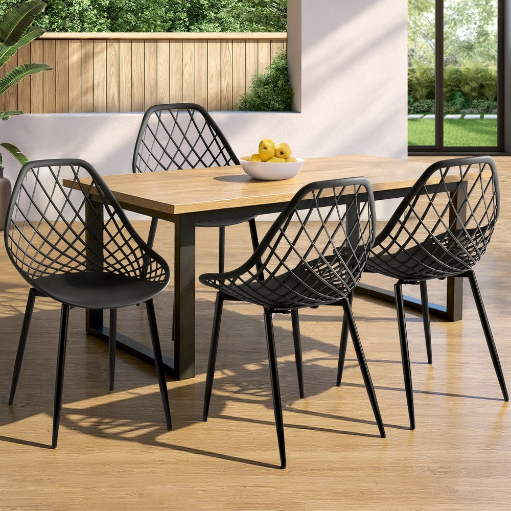 Dining table with four black metal chairs on a wooden deck.