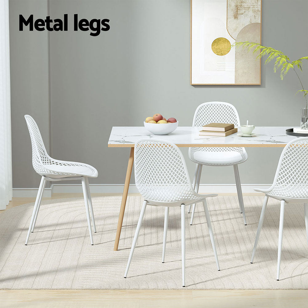 4-piece Gardeon Outdoor Dining Chairs in White around a rectangle table with wooden legs set on a cream patterned floor mat on a laminated floor with a wall and picture hanging behind it.