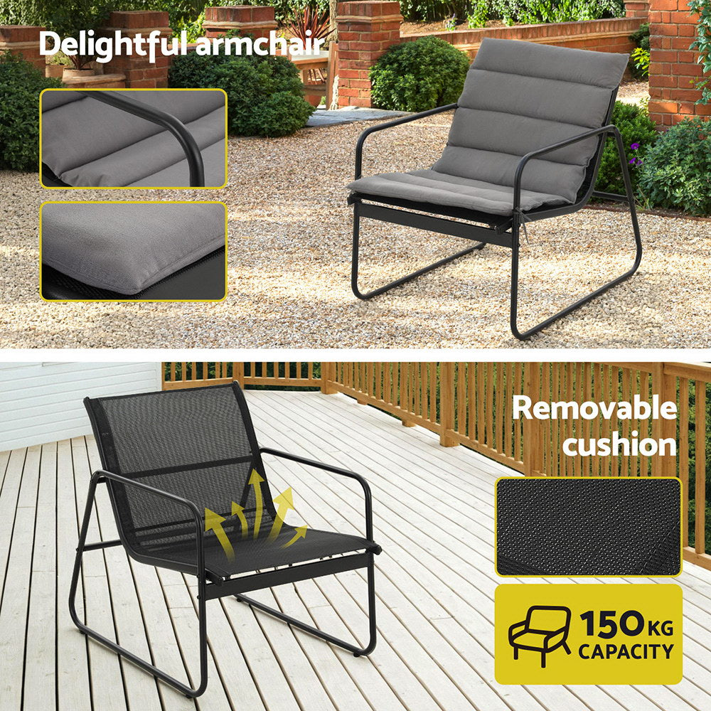 Outdoor armchair with gray cushions and black metal frame, shown on a patio and deck.