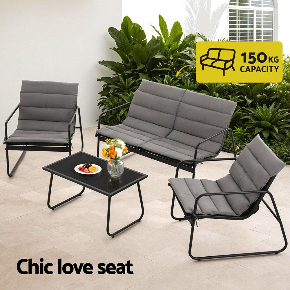 Outdoor furniture set with a love seat, two chairs, and a table in a garden setting.