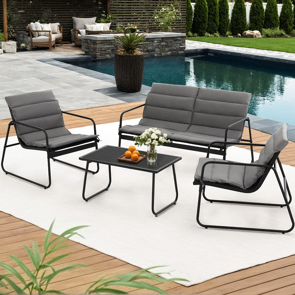 Outdoor patio set with gray cushions and black frames by a pool