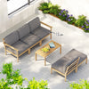 Outdoor furniture set with gray cushions and wooden frames on a patio with plants and flowers.