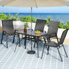 Outdoor patio set with table, chairs, and umbrella on a tiled deck by the ocean.