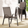 A set of six brown outdoor dining chairs made of metal and plastic, featuring a stackable design and anti-slip feet. Five chairs are stacked and one on its own, all set on a patio in front of a wooden house wall and window.