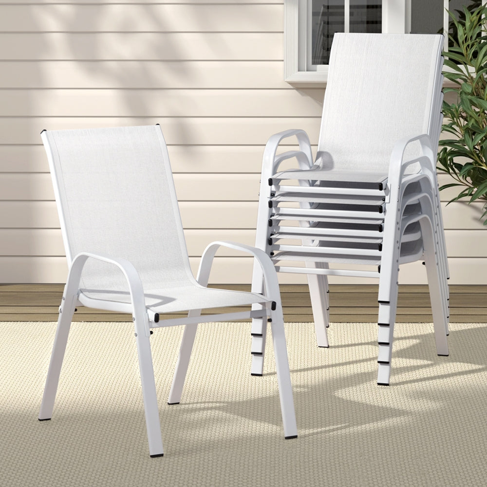 White outdoor chairs stacked on a patio with a neutral background