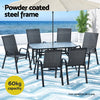 Outdoor dining set with table and chairs on a patio with ocean view, featuring text about powder-coated steel frame and capacity.