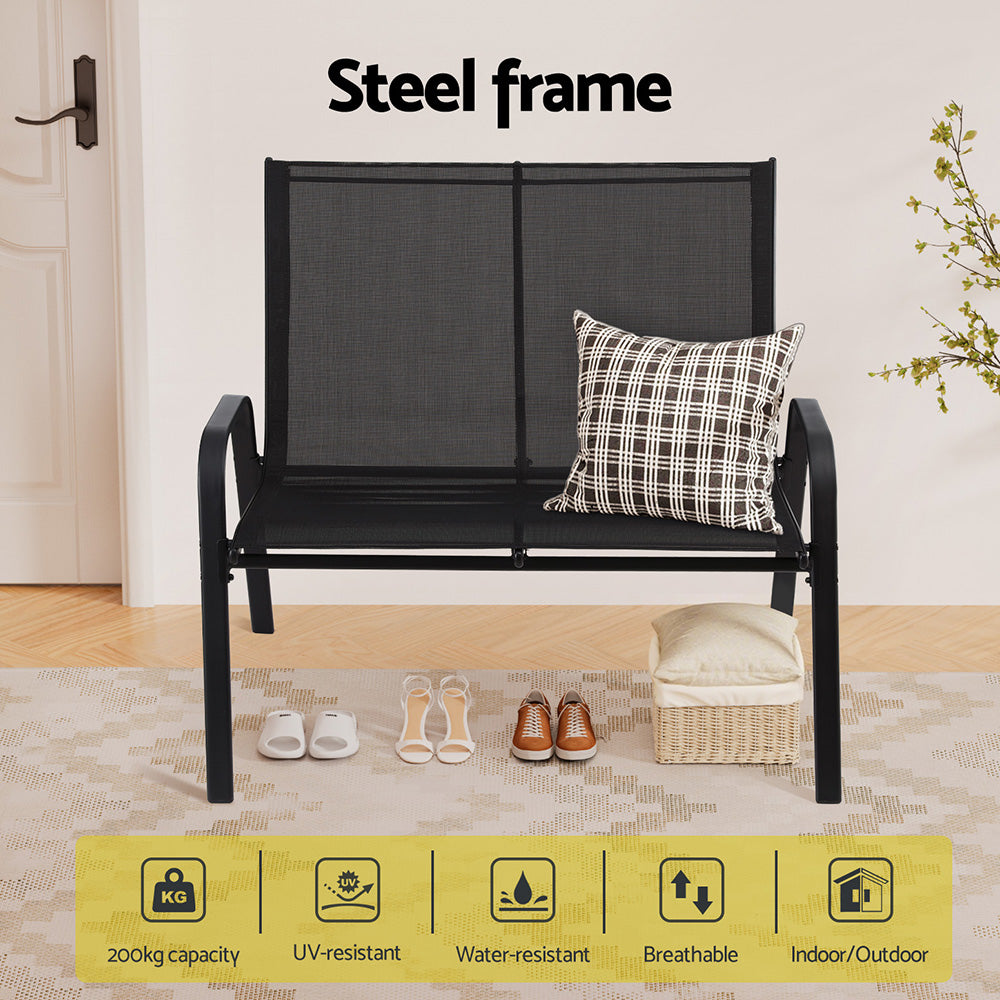 Black metal bench with a cushion on a wooden floor, featuring text about the steel frame.