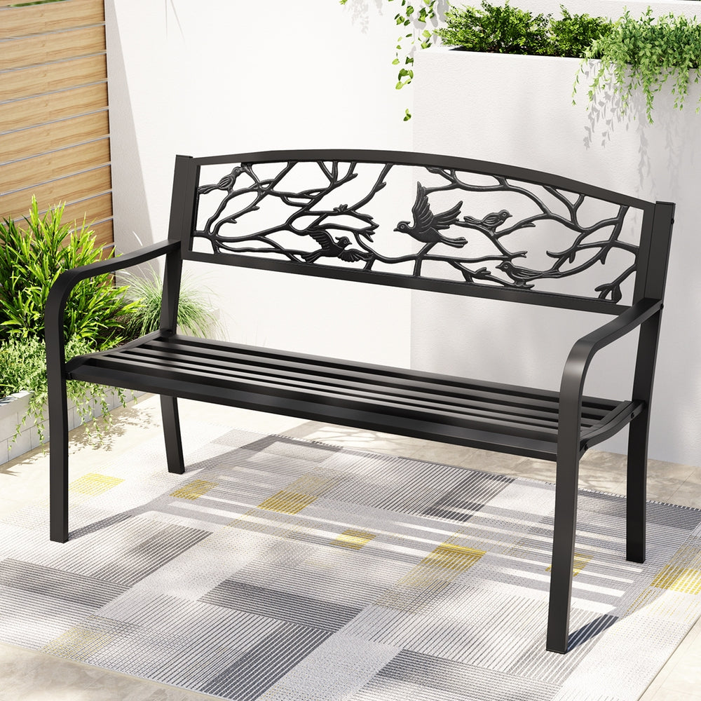 Black metal bench with decorative design on a patio
