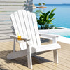 White Adirondack chair on a wooden deck with a pool and ocean view.