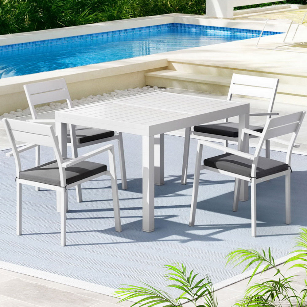 Outdoor dining set with table and chairs by a pool