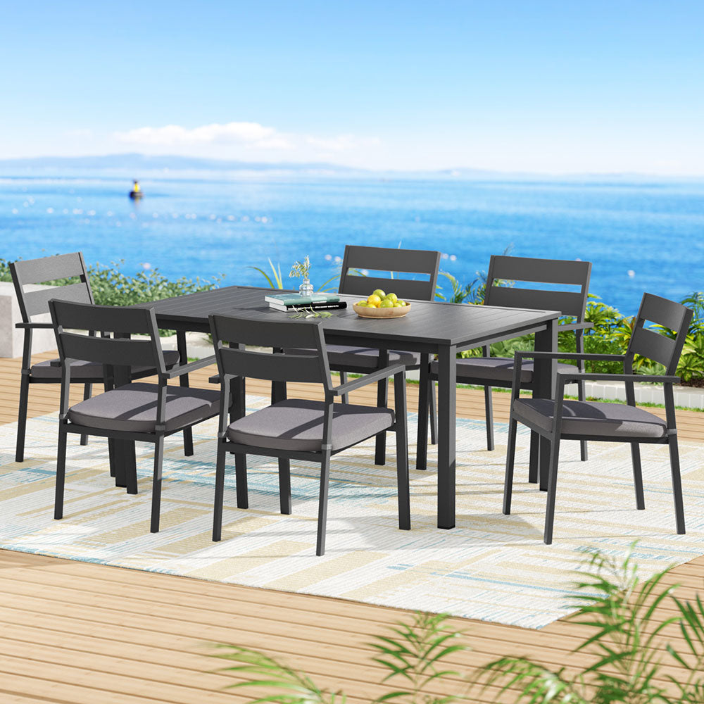 Outdoor dining set with table and chairs on a deck by the sea