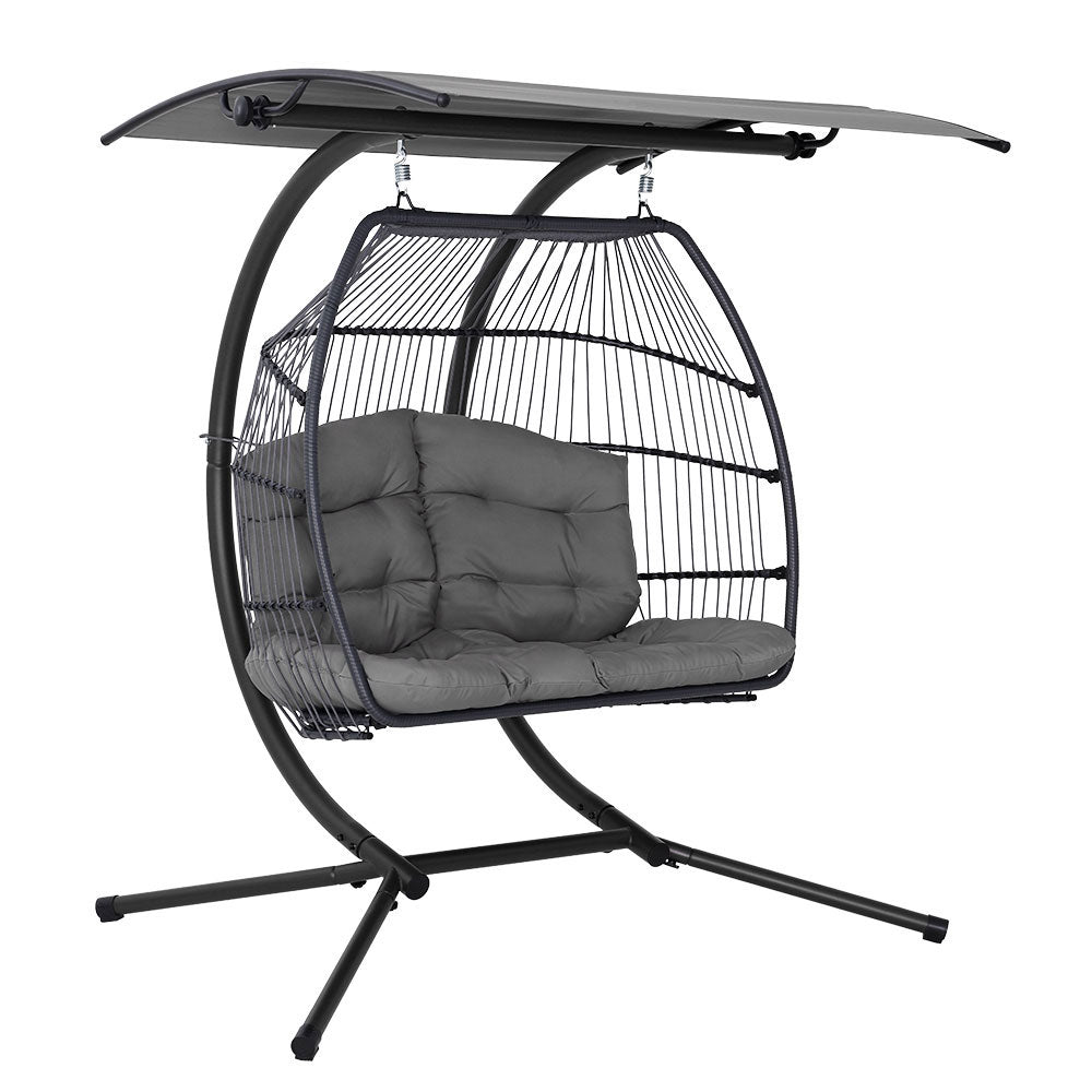 Hanging chair with dark gray cushion and metal stand on a white background