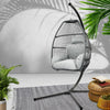 Hanging egg chair with white cushions in a room with plants and a rug.