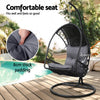 Black wicker hanging chair with gray cushion on a wooden deck, featuring close-up of padding and text about comfort.