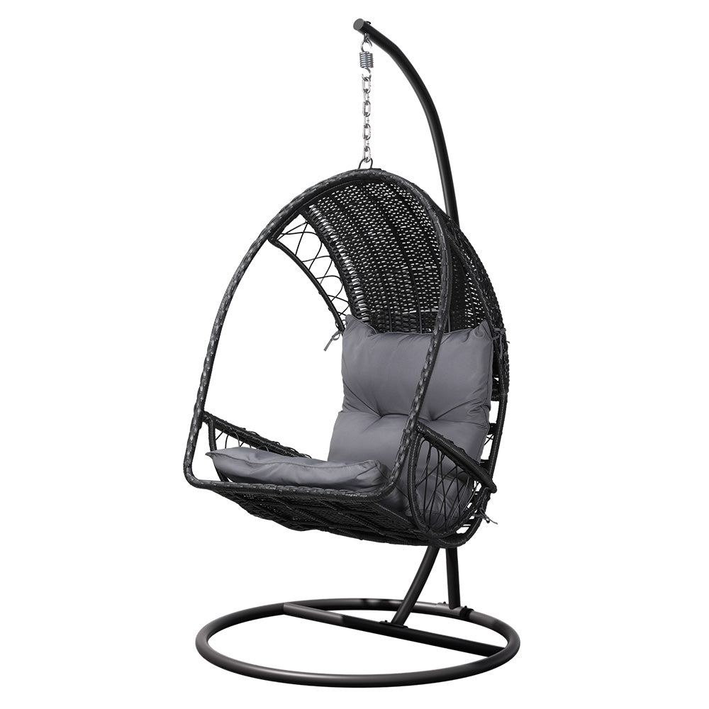 An outdoor egg swing chair with a black wicker frame and stand, featuring a gray cushion.