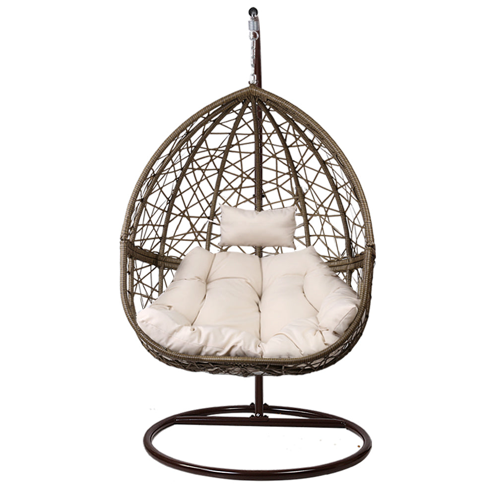 Wicker hanging chair with white cushions on a white background