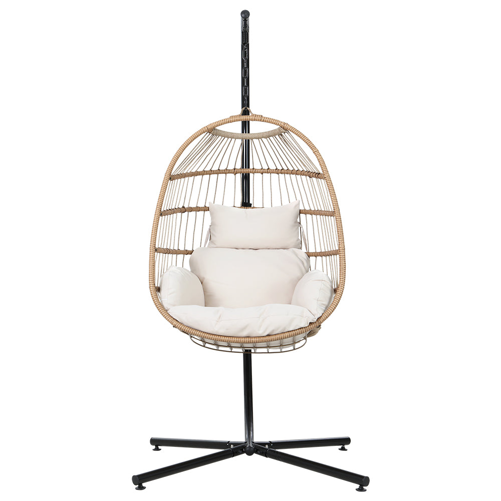 Wicker hanging chair with white cushions on a black stand against a white background