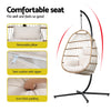 Hanging chair with white cushion and black stand, featuring text about comfort and features.