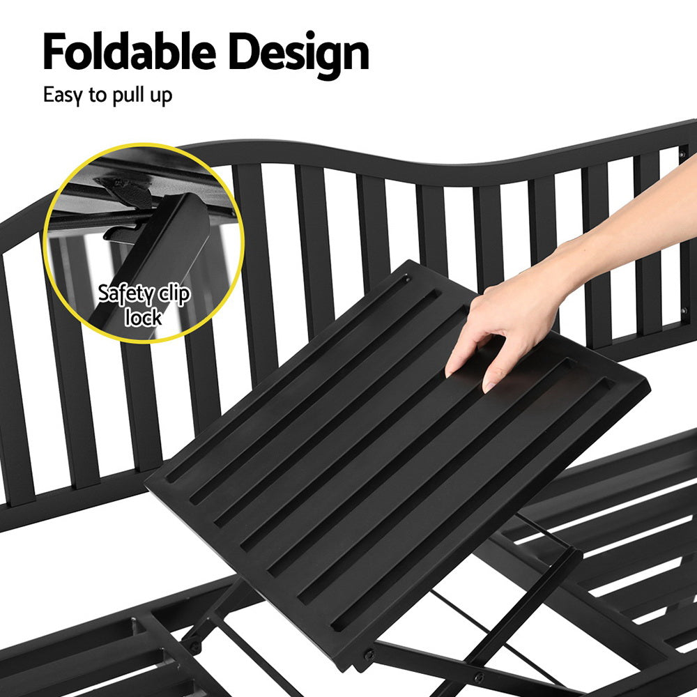 A close up of the foldable table being pulled up with an inset image of the safety clip lock in a black steel outdoor garden bench and set on a white background.