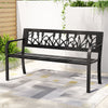 Black metal bench with decorative backrest on a patio