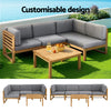 Outdoor furniture set with wooden frame and gray cushions on a grassy area.