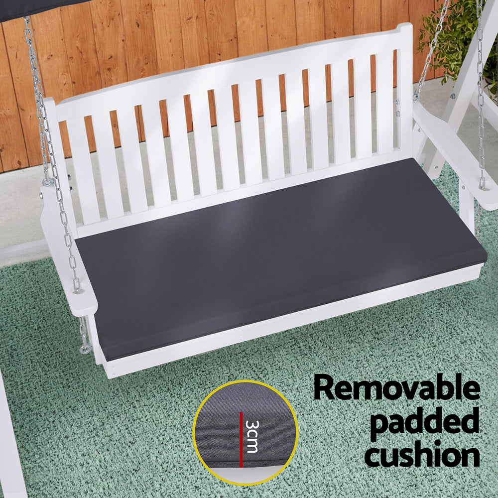 White wooden swing with a dark gray cushion on a green floor, with text indicating it is removable and padded.