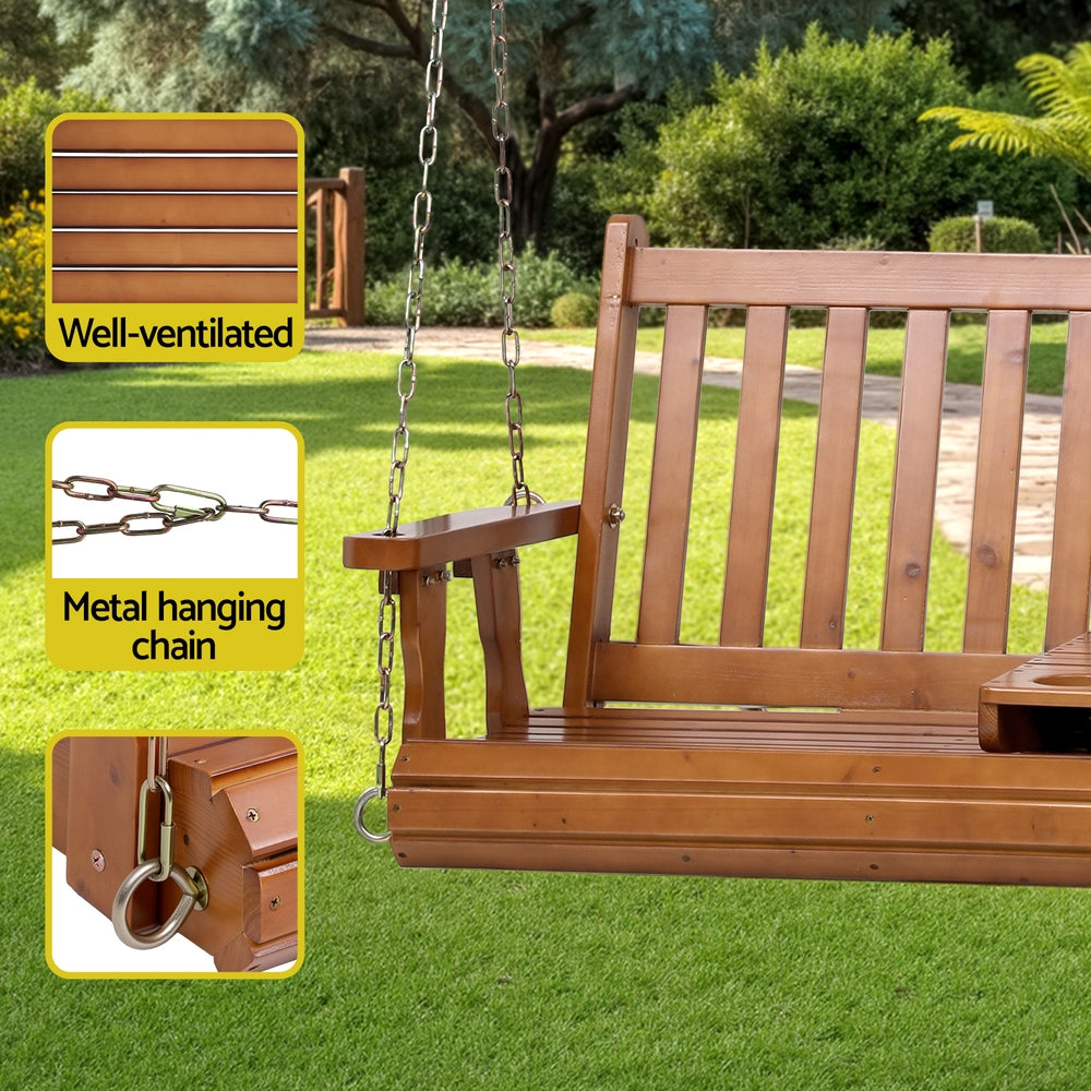 Wooden porch swing with metal hanging chain on a grassy outdoor setting
