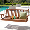 Wooden swing bench with a green pillow on a patio near a pool