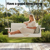 Woman sitting on a white wooden swing in a garden with text 'Have a good time swing'.