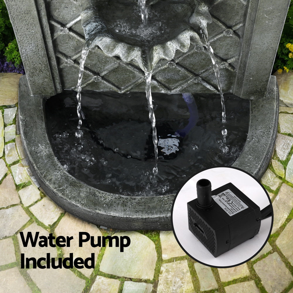 A close-up image showing the bottom of a wall mounted garden feature with an inserted image of the water pump set in a garden on a slate paved area