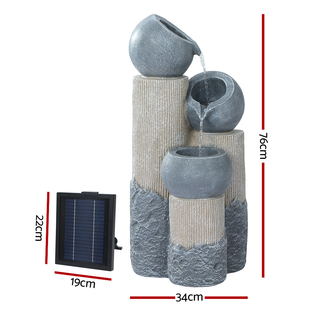 A three-tier cascading water fountain feature with LED lights, made of polyresin, in a grey and beige colour featuring a solar panel on the left, showing the dimensions of the item; all set against a white background.