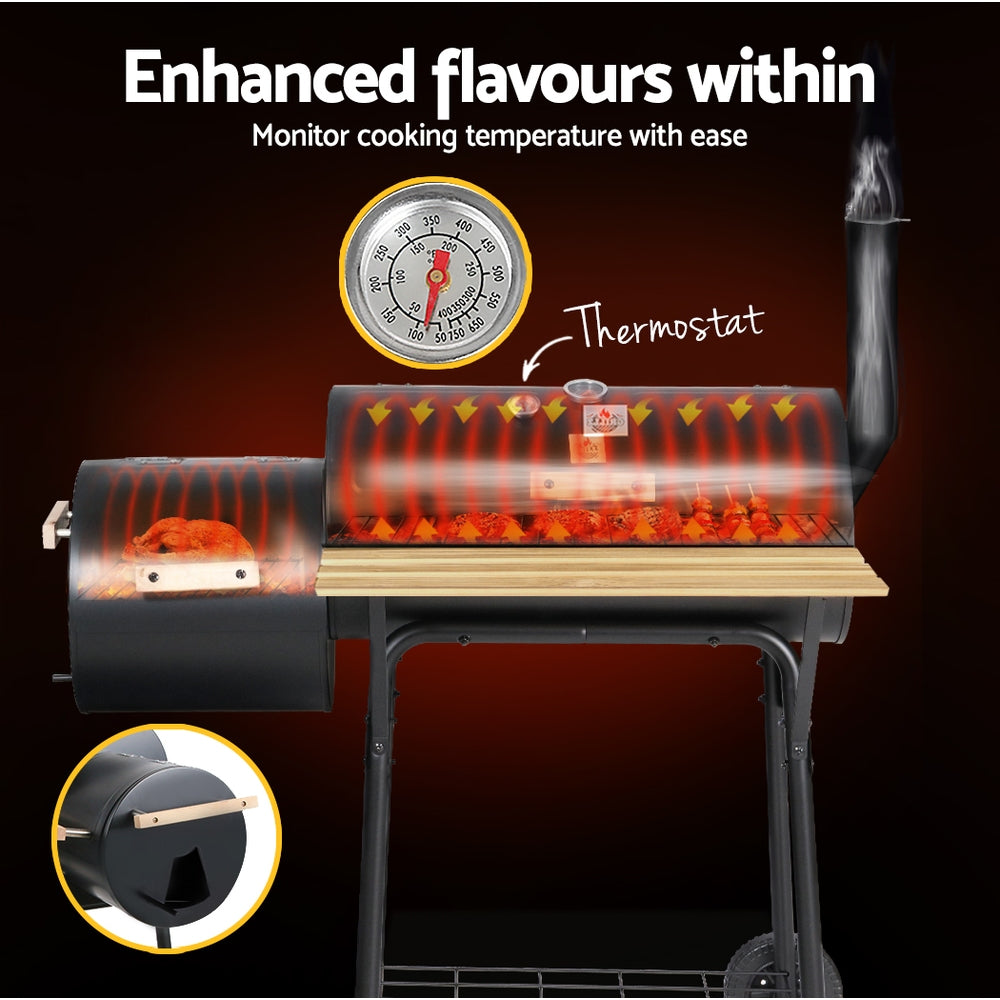 Black Grillz 2-in-1 offset charcoal smoker showcasing its thermostat and its heating distribution inside, a side firebox showing a chicken being roasted inside and large front shelf, set on a dark background.