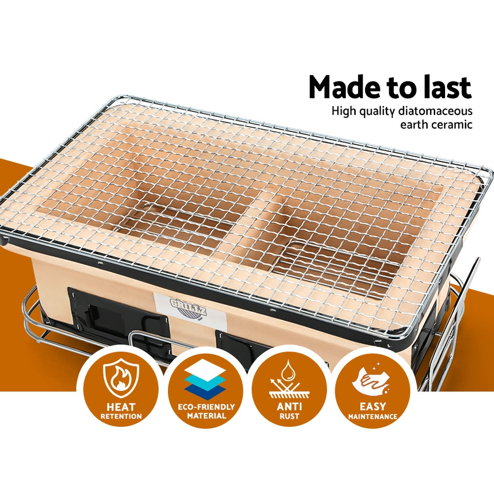 looking down and into the Grillz BBQ Grill Tabletop Charcoal Smoker on a bench and white background.