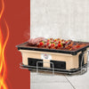 Grillz BBQ Grill Tabletop Charcoal Smoker with setak, skerwered kebabs and chicken drumsticks cooking, set on a tiled floor with painted wall in the background.