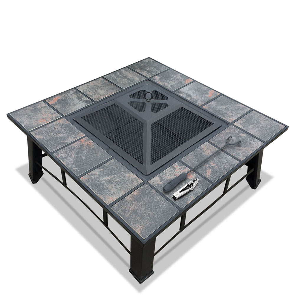 An outdoor fire pit BBQ grill with a grey finish, featuring a mesh dome, ice tray, and a BBQ grilling rack on top, set on a black steel frame with ceramic tiles on a white background.
