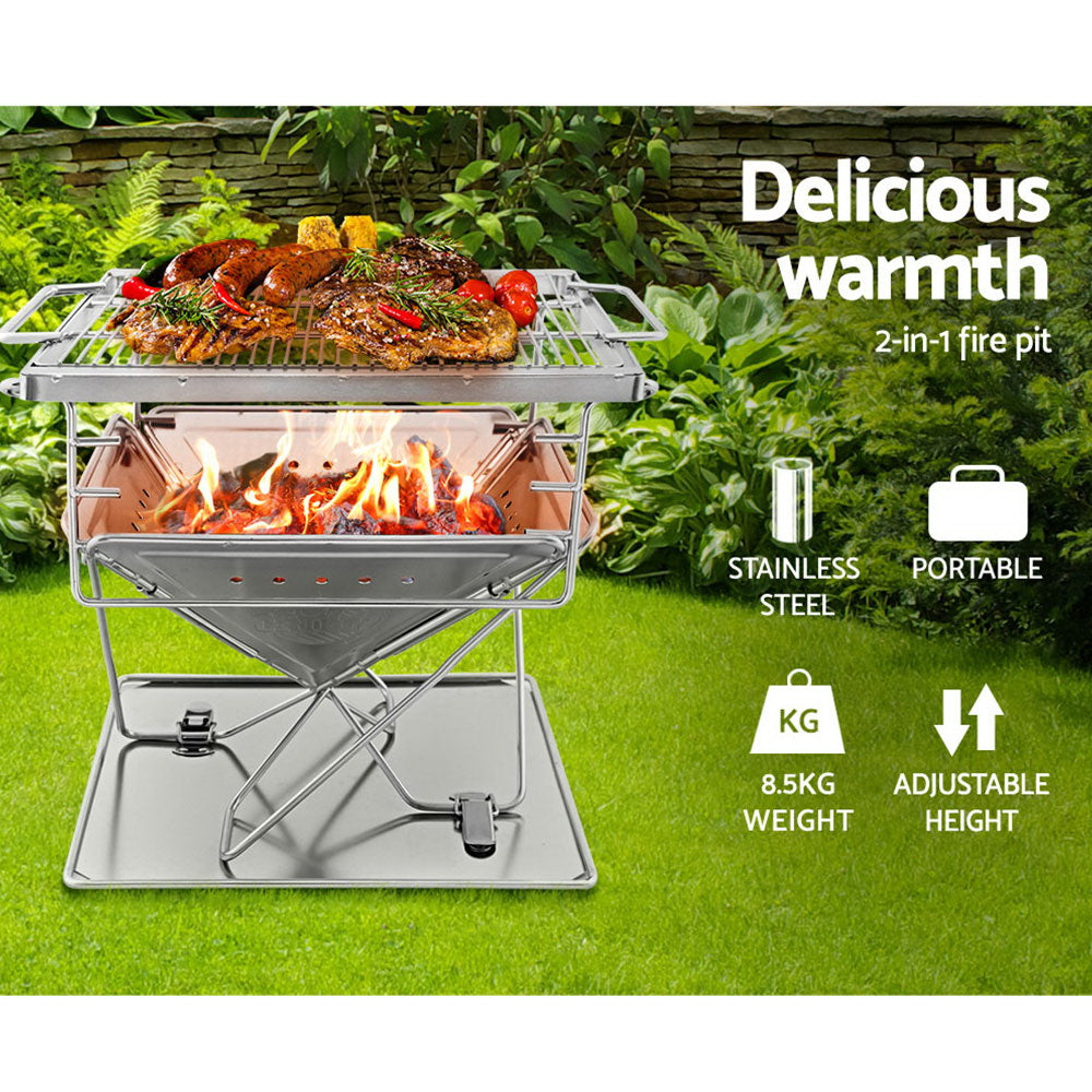 A portable stainless steel Grillz 2-in-1 Fire Pit BBQ Grill, cooking steaks, sausages and vegetables with labels showing that it is stainless steel, portable, 8.5kg weight and adjustable height. Set on green grass in a garden setting with plants and slate wall in the background.