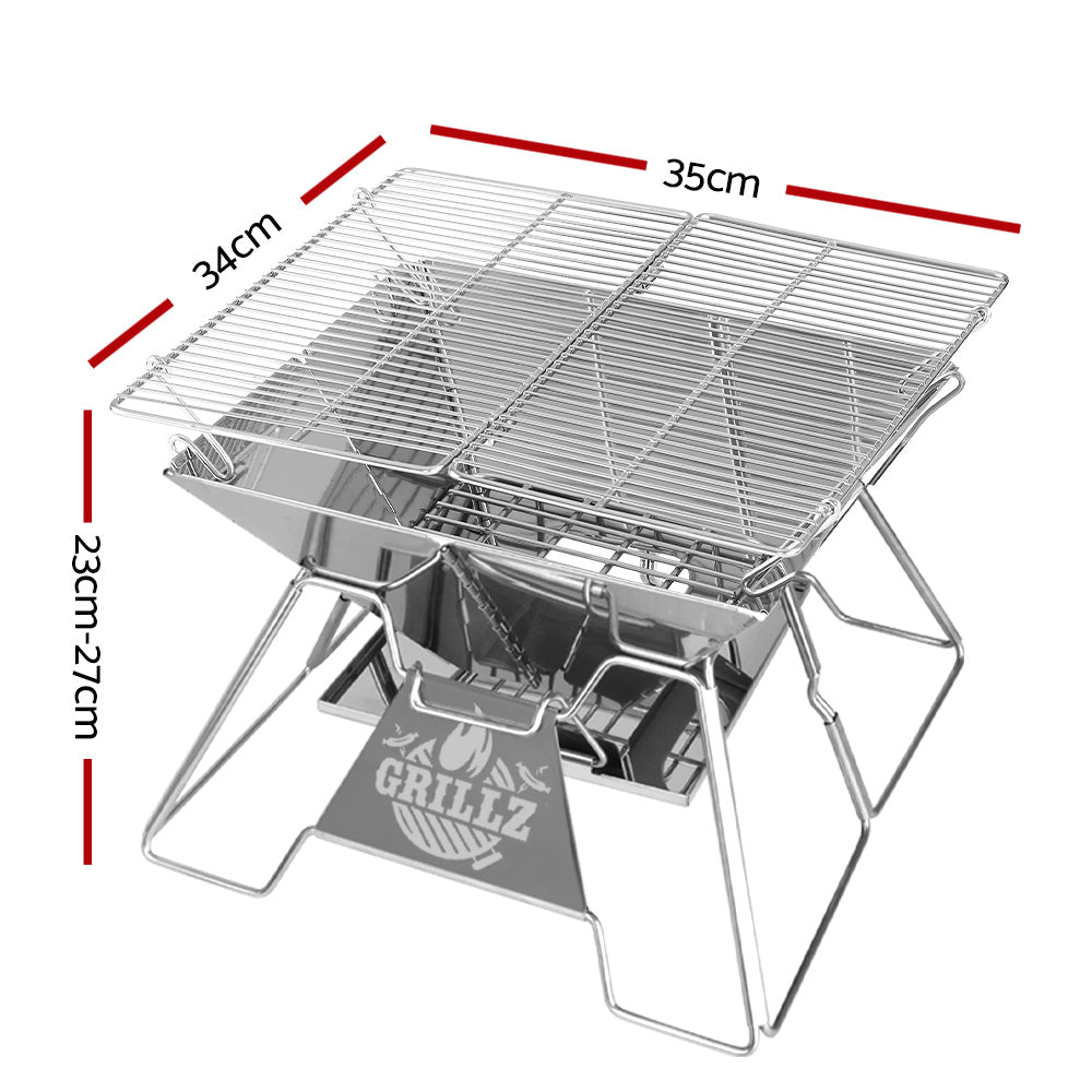 A portable stainless steel fire pit BBQ grill with a carry bag. It features a grill rack and an ashtray. Showing its dimensions and set on a white background.