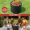 Black fire pit and BBQ grill with food on a grassy background, surrounded by people enjoying a fire.