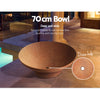 Grillz traditional round Fire Pit Bowl Cast Iron Rustic set in an outdoor verandah on a slate tiled flooring beside some pillars with house in the background.