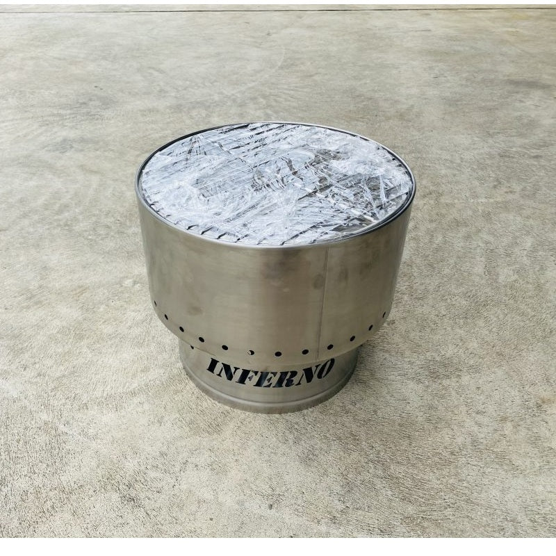 Inferno Smokeless Fire Pit with cooking grill on top; on a concrete surface, branded 'Inferno'.