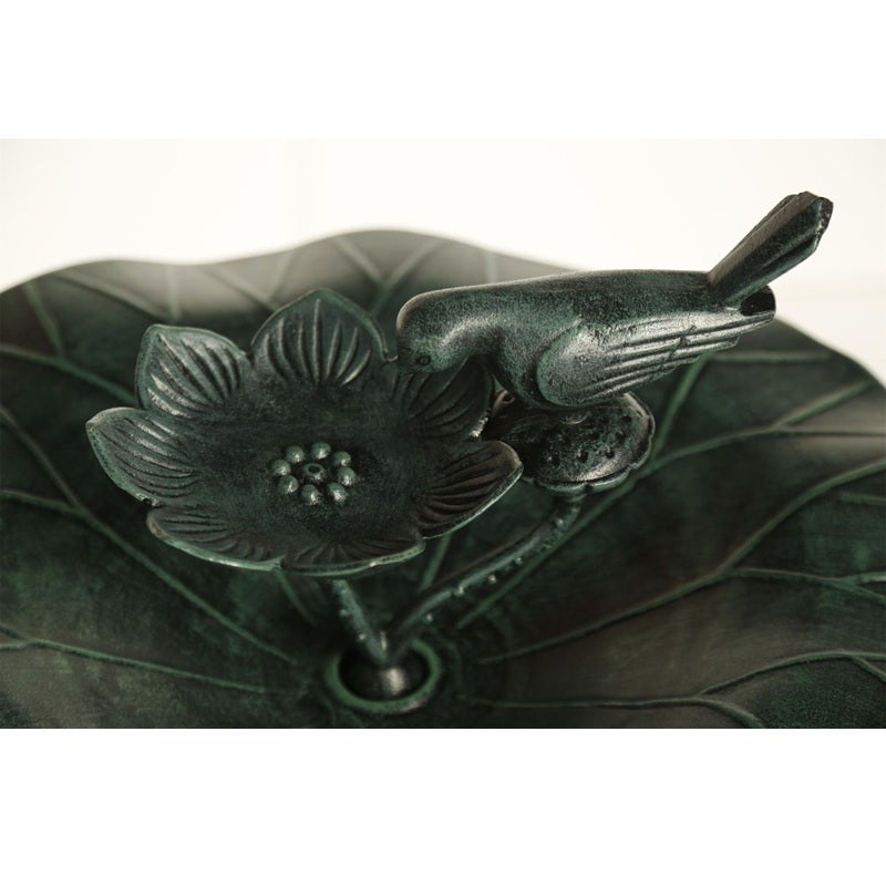 Decorative metal piece with floral design on a leaf-shaped base