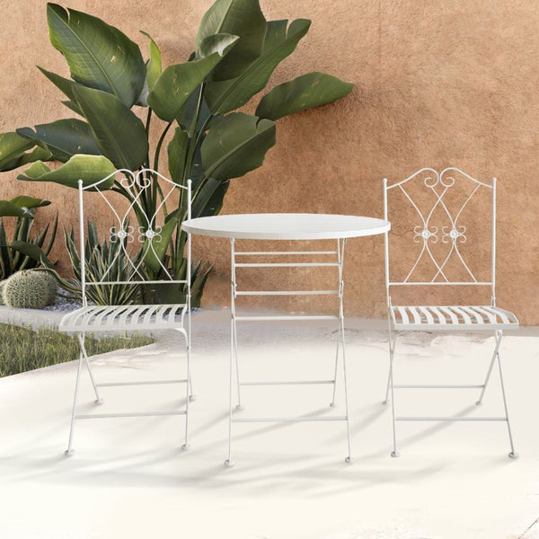 White metal outdoor table and chairs with decorative backrests on a light surface.