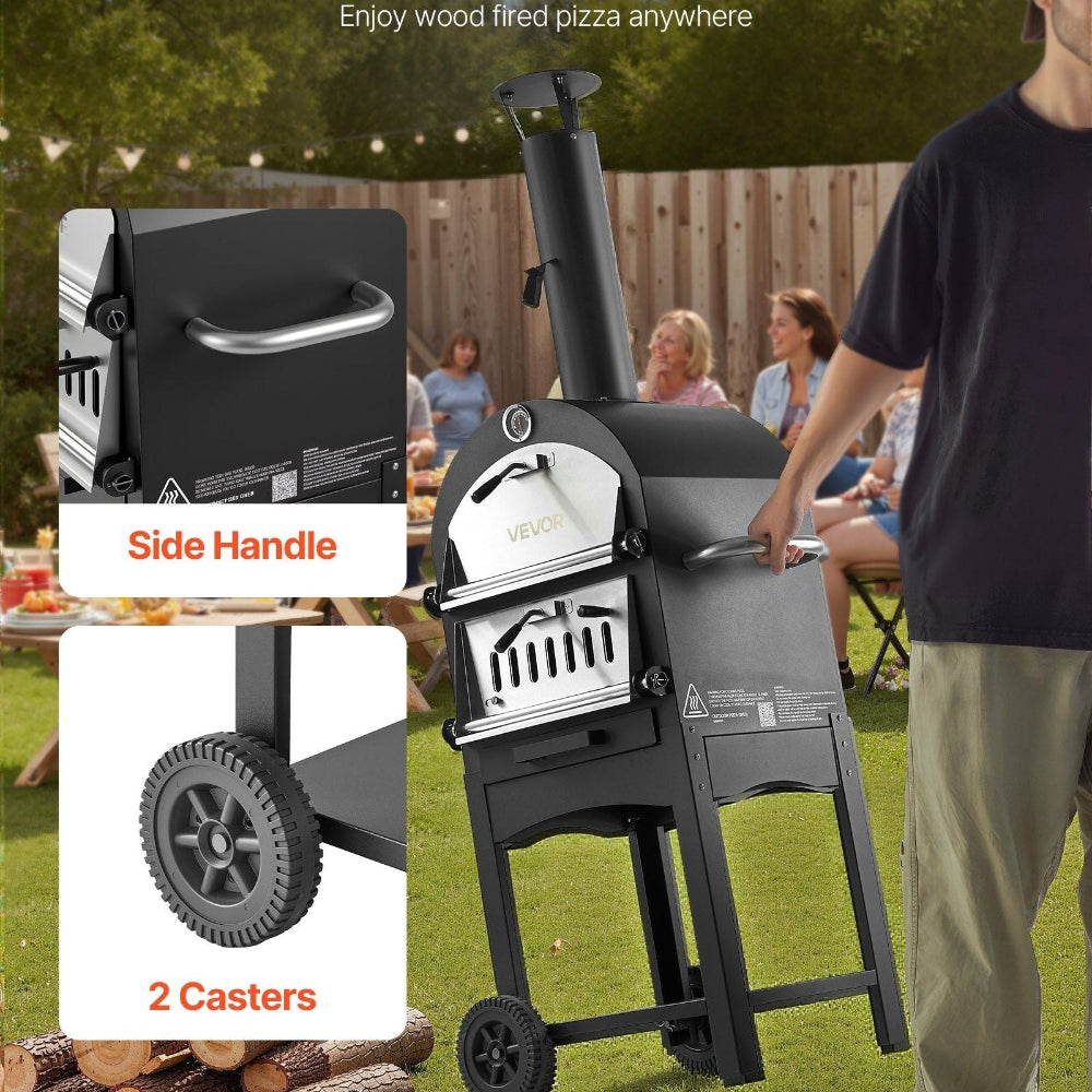 Portable wood-fired pizza oven with casters and side handle, shown outdoors with people in the background.