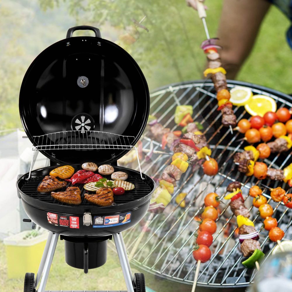 A portable charcoal BBQ smoker with a black enameled firebowl, lid, chrome plated vent discs, and a tripod design. Variety of foods being grilled and close up of another grill top in the background also with food cooking.