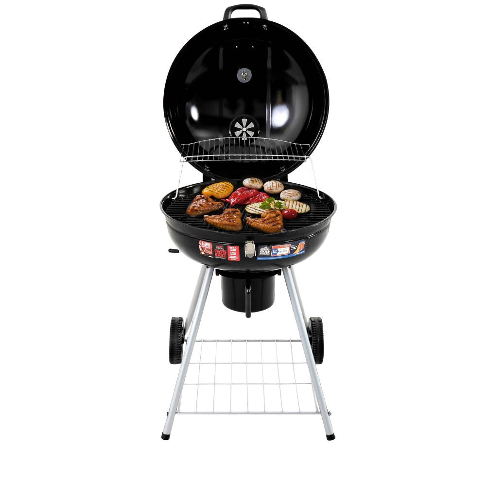 A portable charcoal BBQ smoker with an enameled firebowl and lid, in a tripod design. It has wheels and a storage shelf beneath, lid is open showing meat cooked on the grill top.